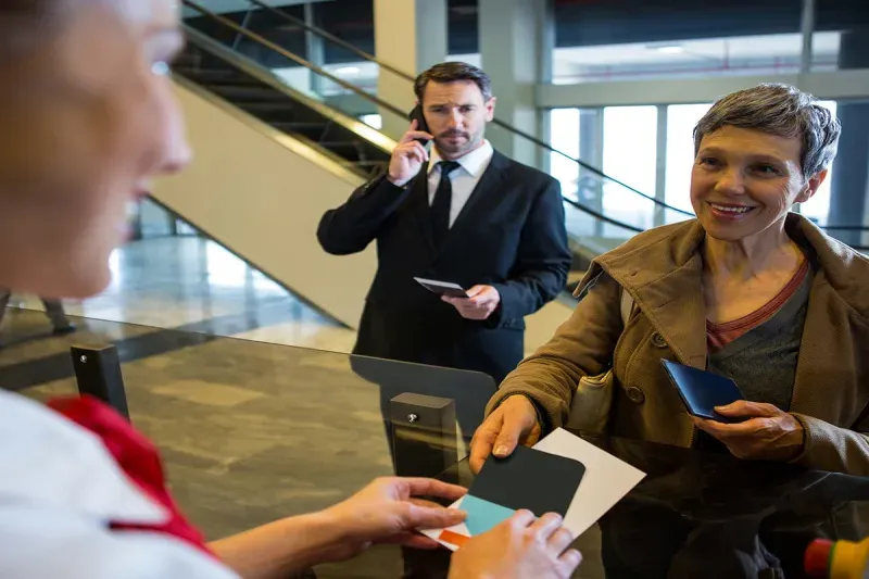 female-staff-giving-boarding-pass-passenger.webp